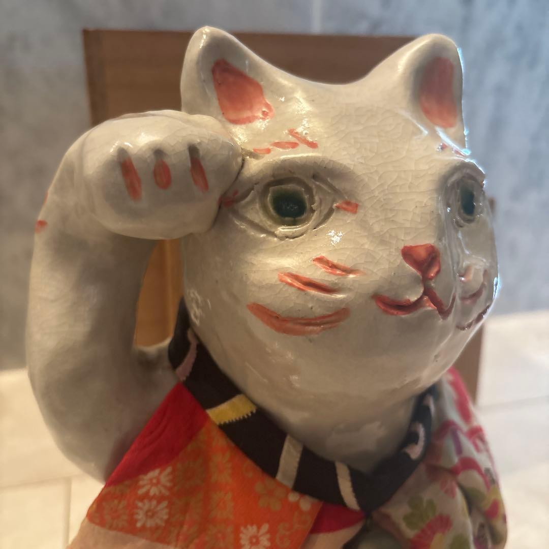 作家さんによる大きな瞳でにっこりと笑う着物の前掛けも美しい招き猫