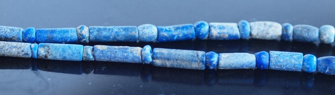 古代濃紺ラピスの管玉や丸玉をほぼ左右対称に編み、トップに斧型や多面体、80個の連