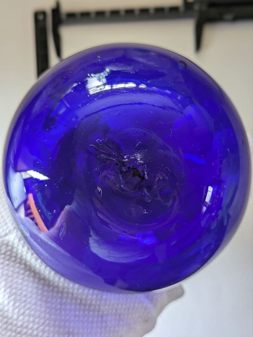 ガラスの浮き玉です。サイズは約90㍉×90㍉です。瑠璃色？少し製造過程の凹凸有り