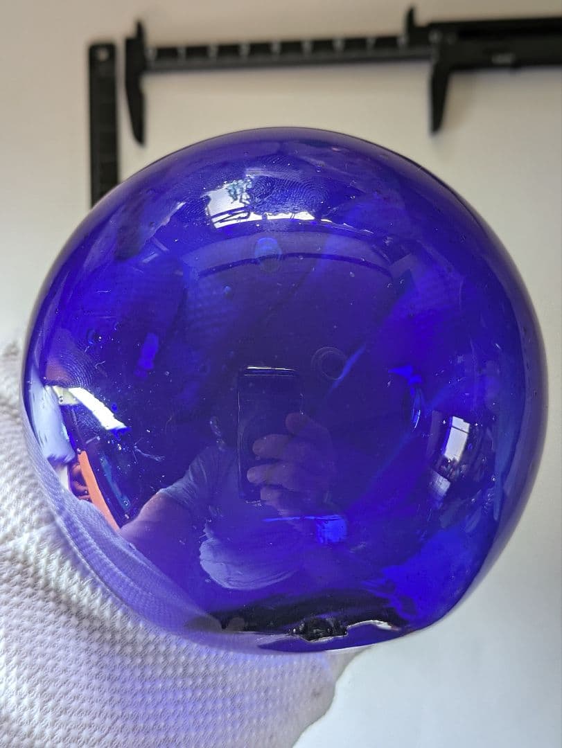 ガラスの浮き玉です。サイズは約90㍉×90㍉です。瑠璃色？少し製造過程の凹凸有り